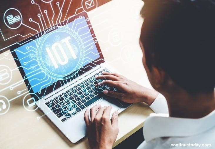 man holding a laptop with Internet of Things