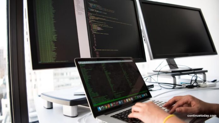human hand working on laptop with desktops for software development