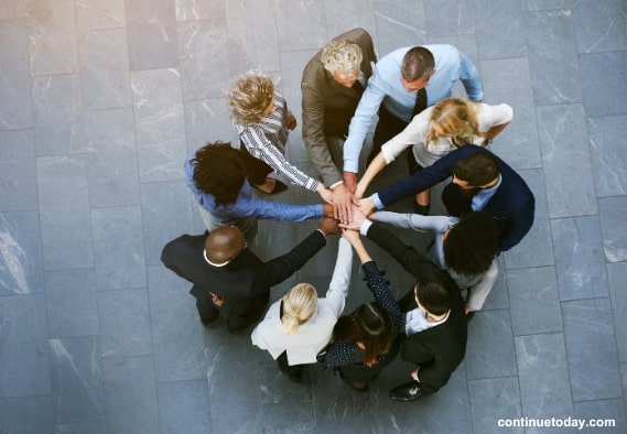 A group of people holding hands for building community to promote NFT